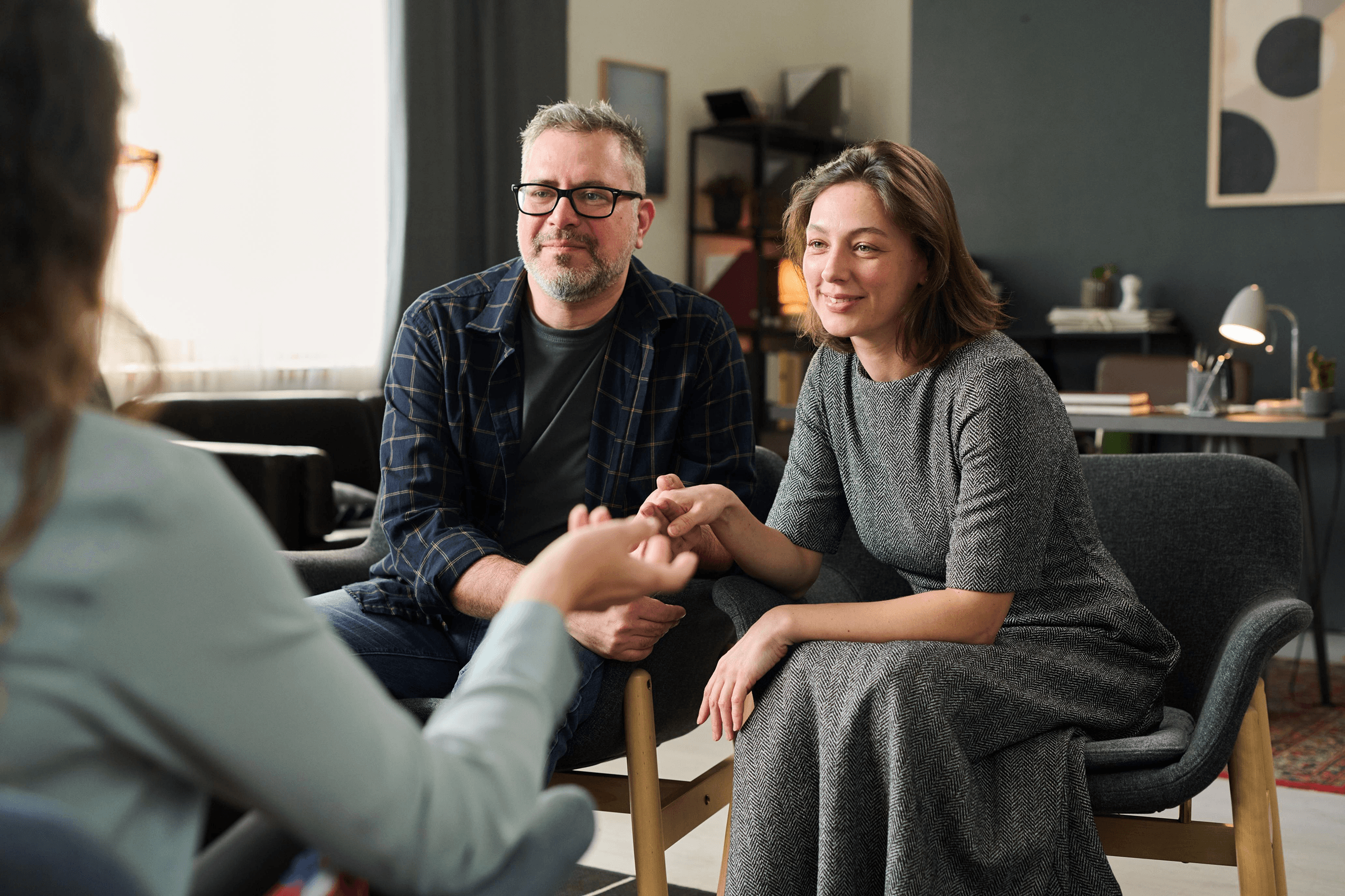 Couple holding hands during a therapy session.